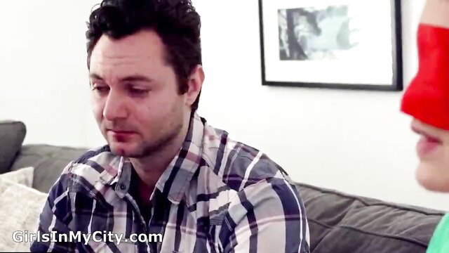 Blindfolded girl teases man on couch, nipples hardening visibly