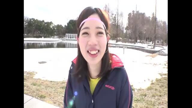 Smiling Asian woman in winter sports jacket at snowy park