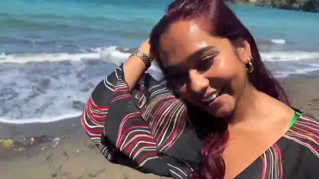 Mia Z smiling on beach wearing striped top