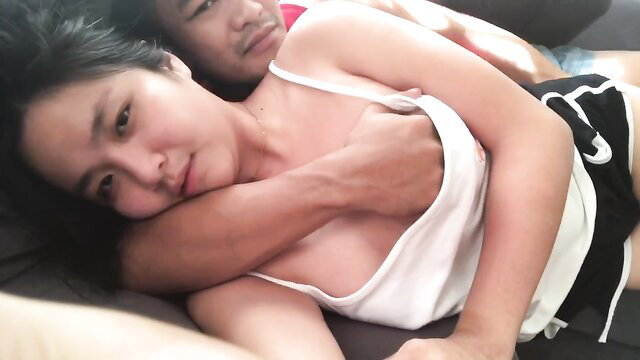 Asian amateur couple cuddling intimately on bed, tank top pulled down exposing tits