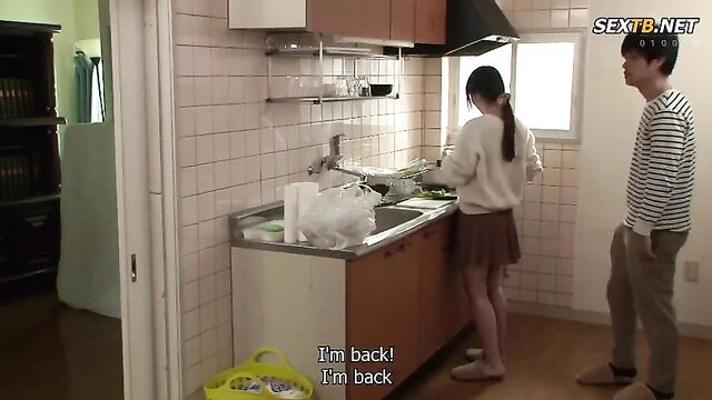 Mizuki Yayoi in skirt washing dishes, guy behind in JAV kitchen scene