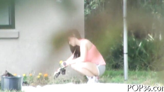 Hot Asian teen in pink tank top and shorts gardening outdoors