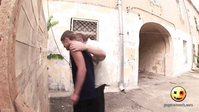 Blonde guy hugging thin man from behind in outdoor amateur gay embrace