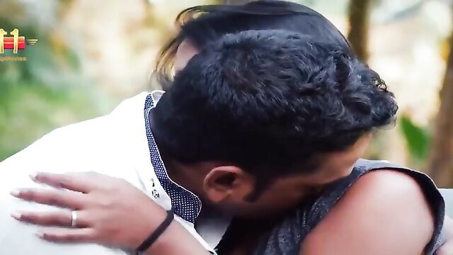 Indian couple embracing passionately in outdoor hug, man nuzzling woman's neck