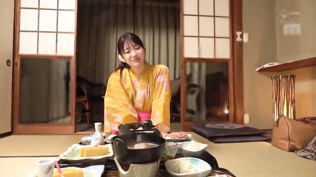 Japanese woman in yellow kimono at hot spring dinner, smiling seductively