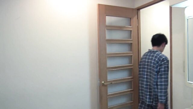 Japanese man in plaid pajamas stands by door in secret affair JAV scene