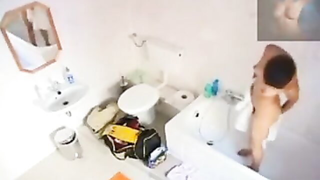 Asian man nude in bathroom with towel, bags around tub
