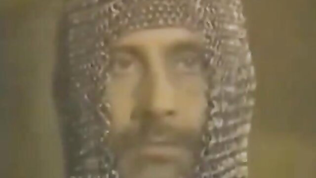 Tom Byron in chainmail coif closeup, Tracie's Fantasies adult video thumbnail