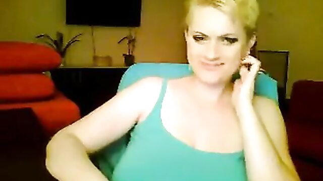 Blonde MILF in tight tank top smiles seductively at camera