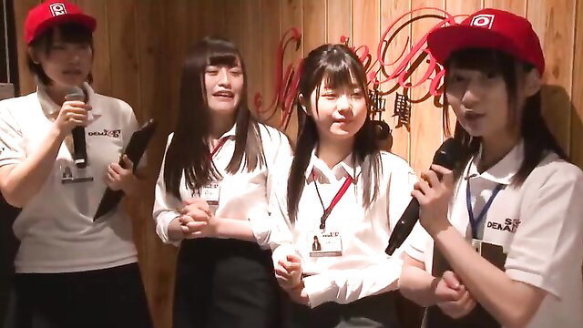 Four cute Japanese schoolgirl-uniformed women holding mics on crazy TV show