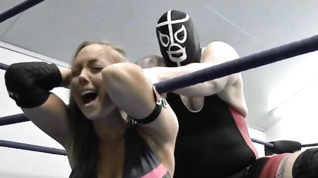 Blonde woman screams in agony as masked luchador crushes her in wrestling ring