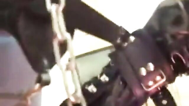 BDSM sub bound in chains and collar, intense fetish restraint closeup