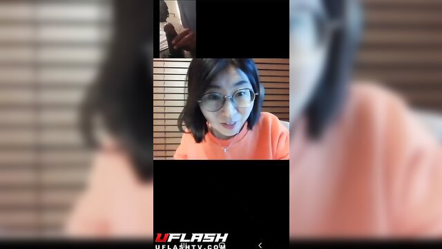 Nerdy Asian tutor with glasses shocked by BBC flash on video call