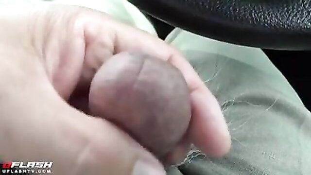 Man holding small erect penis in car parking lot