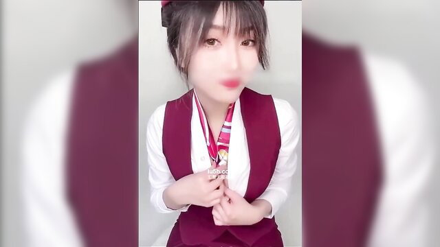 Asian flight attendant in tight uniform teases with glossy lips
