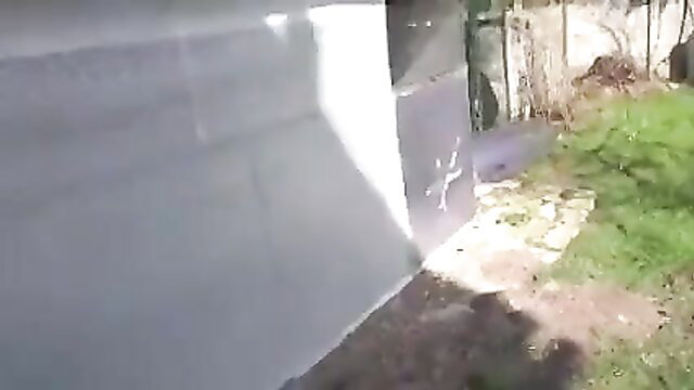 Hot farmer wife by outdoor garage door in backyard