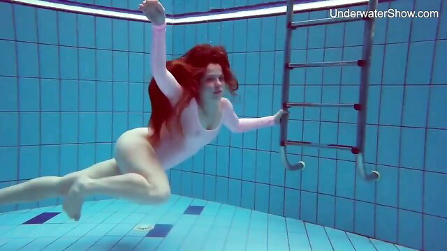 Redhead Simonna swims nude underwater in sexy pose