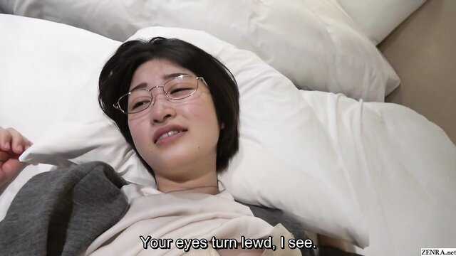 Pale Japanese wife in glasses lies on bed, eyes turn lewd for hotwife fantasy