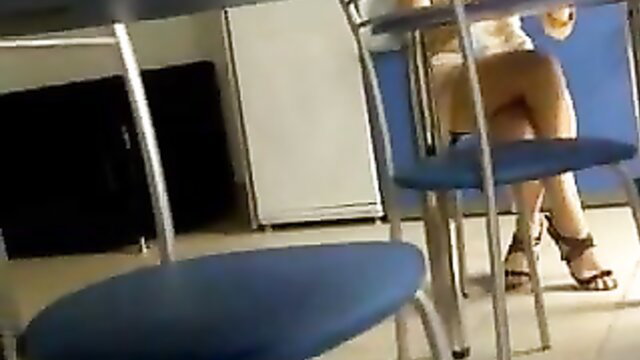 Amateur upskirt view of woman in white top and heels under table