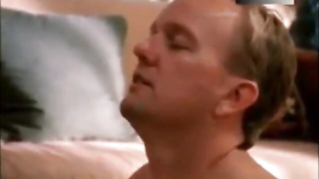 Blonde man lying back in intense adult scene from Learning How to Love