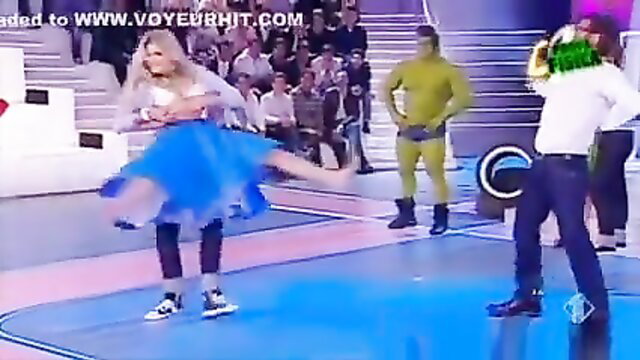 Blonde dancer in blue tutu skirt twirls with nipple slip on stage