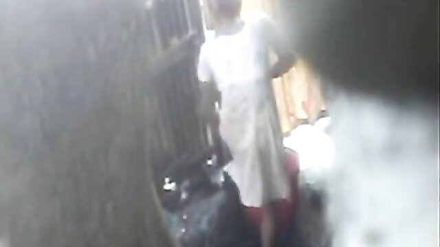 Bangla village woman in white dress near bathroom door