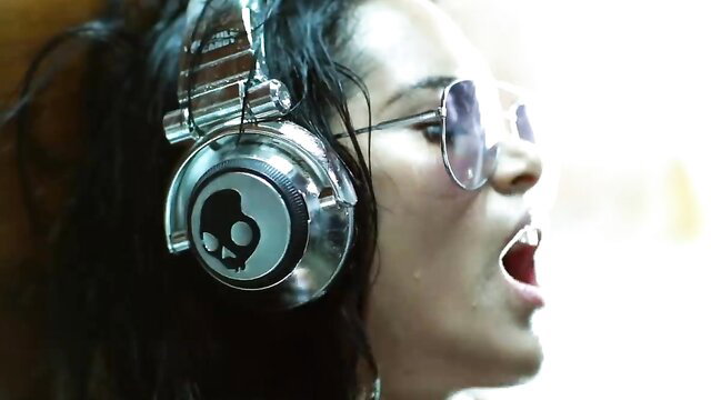 Wet-haired Latina hottie in Skullcandy headphones screaming sexy, Chica Bomb video