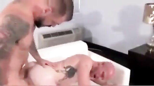 Tattooed hunk fingering bald muscular man's ass on sofa