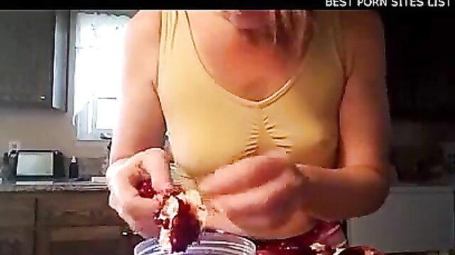 Blonde MILF in tight tank top squeezing juicy pomegranate in kitchen