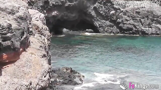 Stunning turquoise cove with rocky cave on family vacation beach