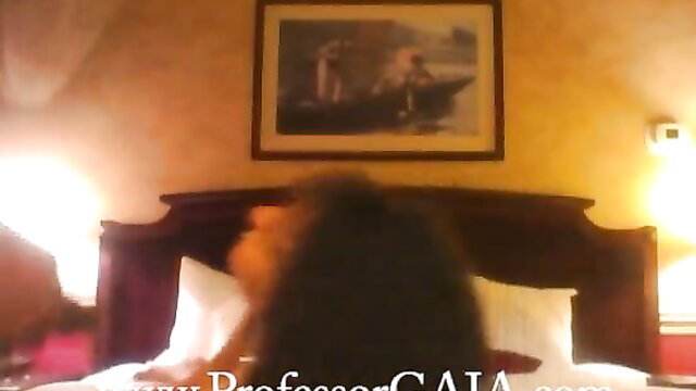Gaia from Swallowed with long dark hair on bed, sexy profile view
