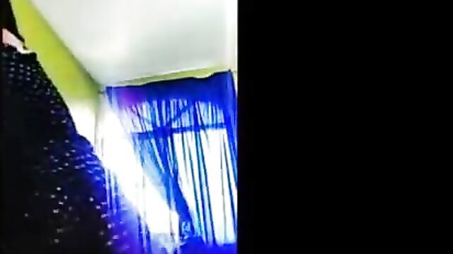 Lonely Indian wife in sparkly black top by blue curtains, teasing pose