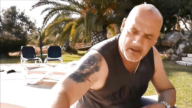 Bald muscular man with tattoos poolside in Mallorca adult video