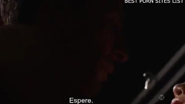 Latina woman with big tits whispers 'Espere' in dim erotic closeup