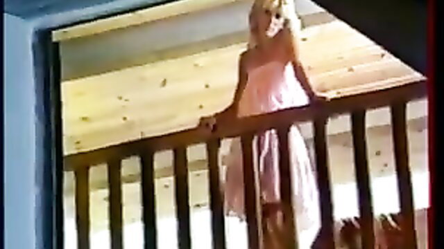 Blonde bombshell in pink dress on balcony, vintage French tease