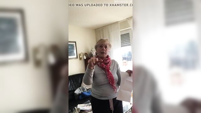 Elderly German MILF mother-in-law in tracksuit holding paper, amateur tease