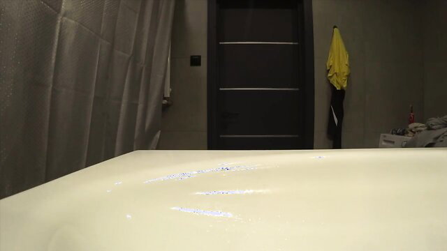 Blurry closeup of bathtub edge with white powder streaks in cheating anal bathroom scene