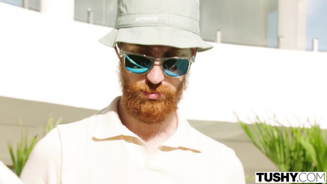 Redhead bearded man in bucket hat smiles for Tushy anal scene