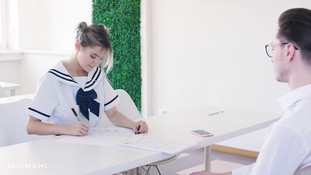 Eva Elfie in schoolgirl sailor uniform writing at desk with guy