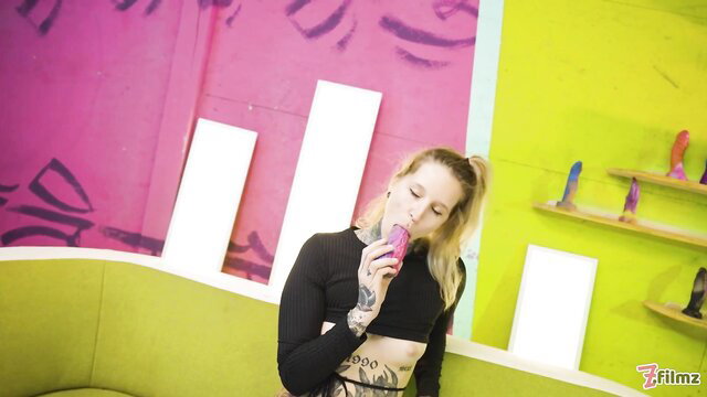 Tattooed blonde Lisa Rock sips drink by dildos in wild toy scene