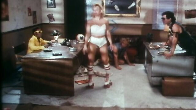 Blonde sporty babe in tube top & shorts stands in classic VCA scene