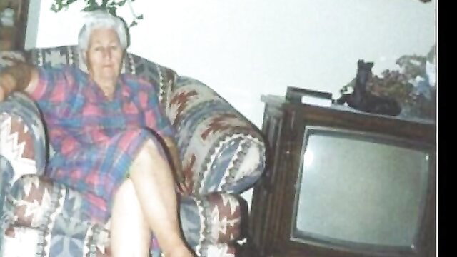 Elderly white granny in dress seated on chair in vintage room