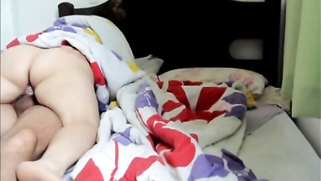 Nude toddler bottom up on colorful bed sheets, explicit child exposure