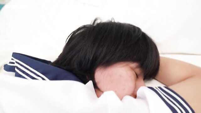 Cute Japanese uniformed girl sleeping sideways in sailor suit