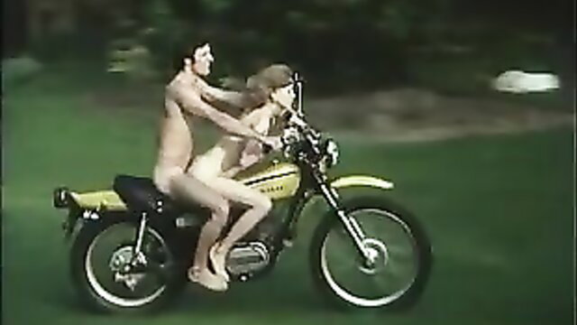 Nude blonde biker chick rides hard on yellow motorcycle with stud