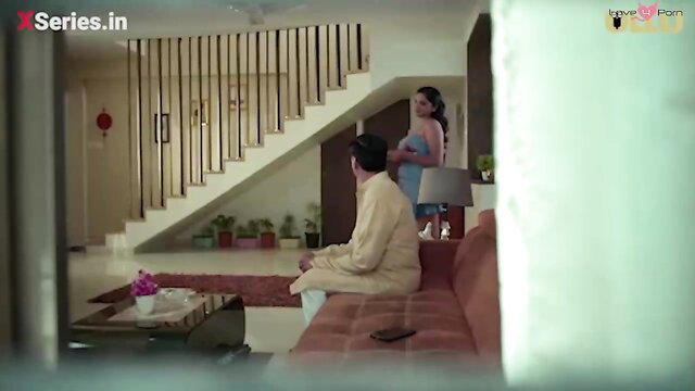 Desi busty babe in blue dress stands by older man on couch in horny web series
