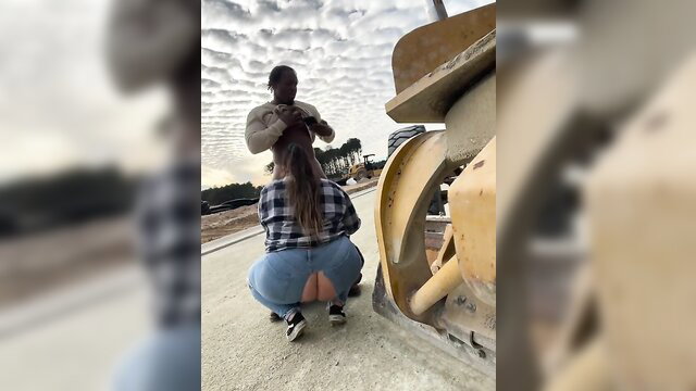Hot brunette squats with ass out next to John Deere as black guy grabs hair