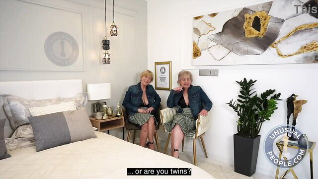 Mature blonde twins in denim jackets & skirts on bed, Guinness award