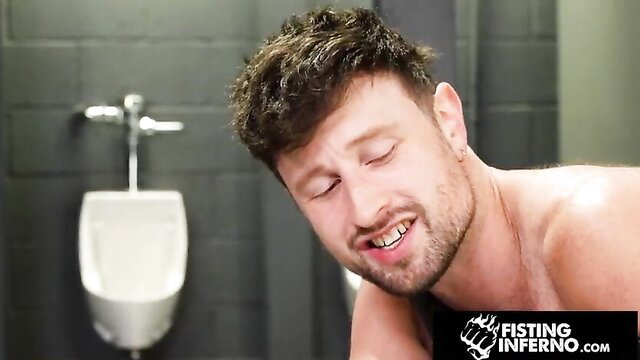 Wrex Wylde naked in bathroom, grinning intensely at camera