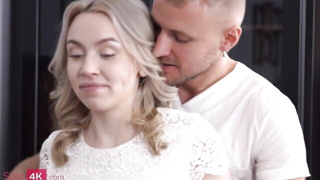 Hot blonde in lace dress kissed passionately by muscular man from behind